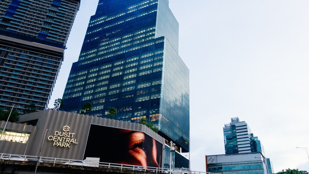 Dusit Central Park tower and shopping centre illuminated in Bangkok skyline.
