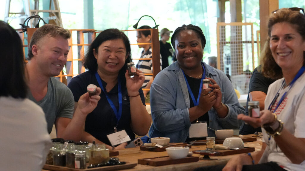 Delegates join community workshop in Krabi, creating local herbal products during Global Meaningful Travel Summit 2025.