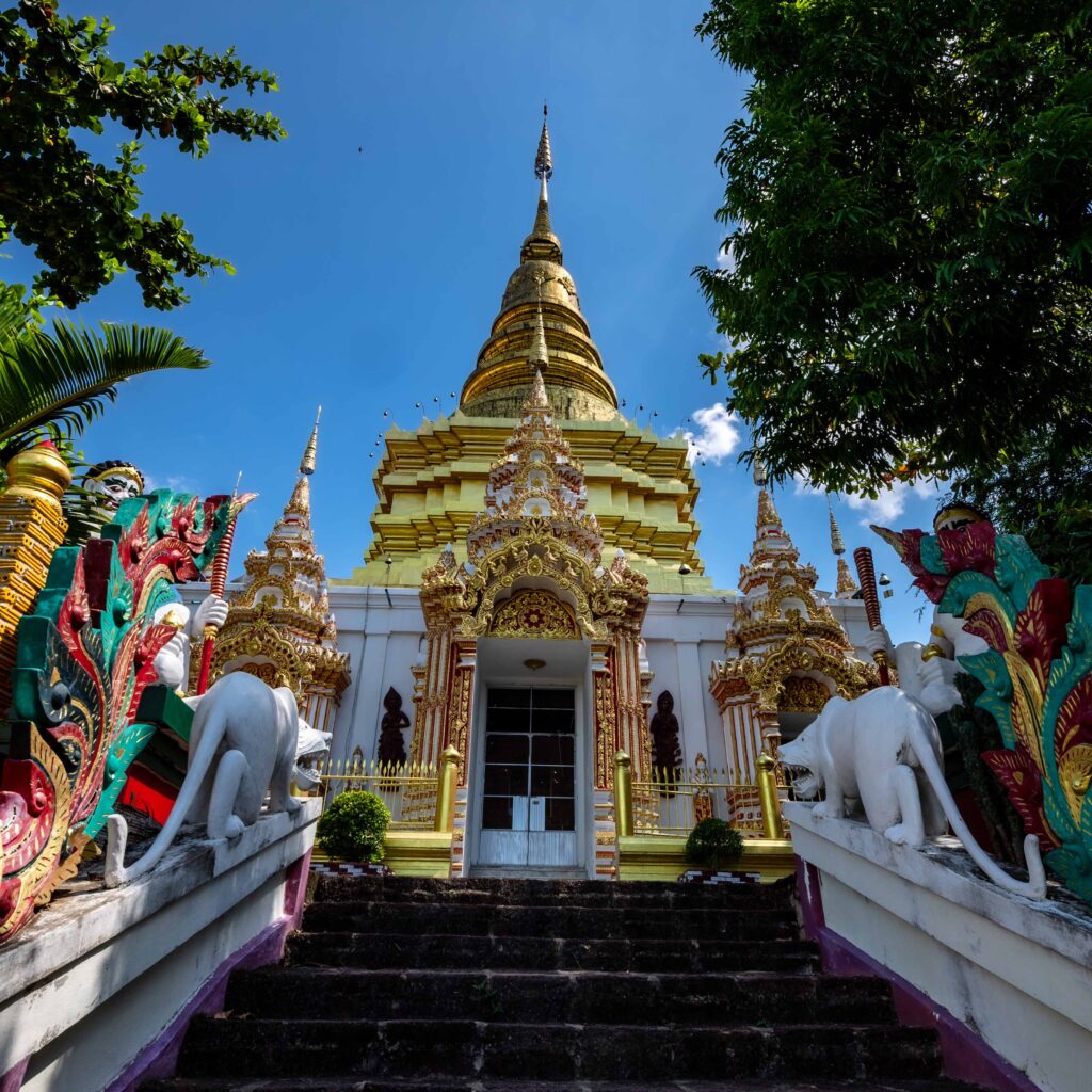 Wat Phra Phutthabat Tak Pha, Lamphun – golden pagoda with ornate carvings, mythical guardian statues, and sacred Buddhist architecture in Northern Thailand.