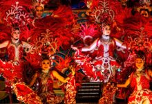 Molam performers in red costumes with feathered headdresses during vibrant show at Molam Festival 2025