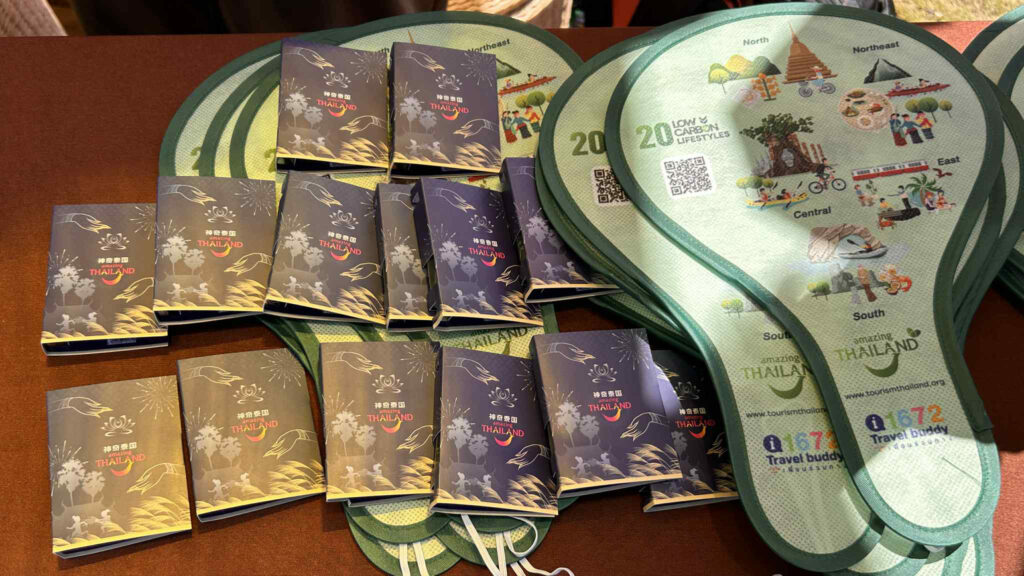 Amazing Thailand Souvenirs Guangzhou – Festival giveaways featuring Amazing Thailand travel-themed booklets and eco-friendly items.