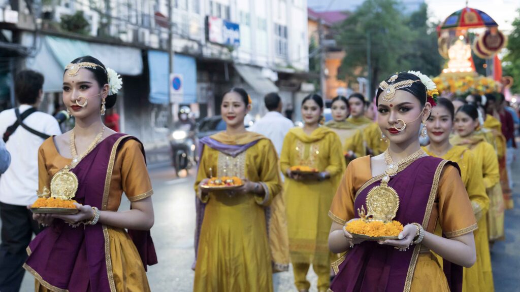 Performers dressed in traditional Indian costumes carry marigold offerings in the Grand Procession of Exquisite Radiance at Phahurat, Bangkok.