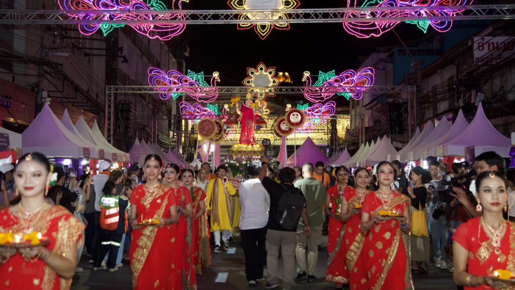 Procession of dancers in red saris carrying oil lamps leads the illuminated parade through Phahurat during the Amazing Thailand Grand Diwali Festival 2025.