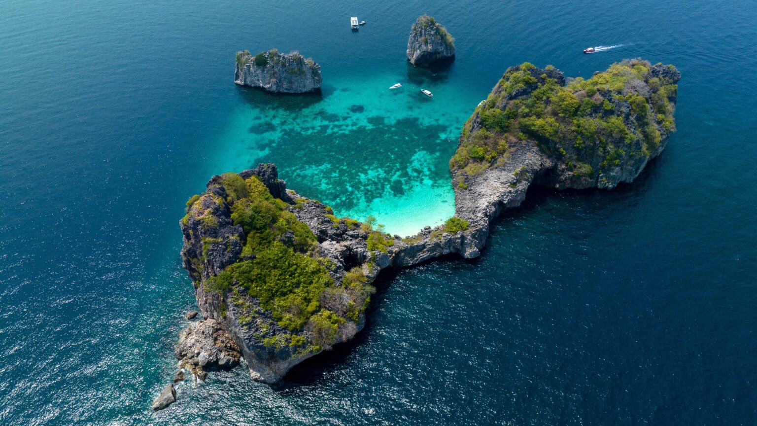 Aerial view of Ko Ha in Mu Ko Lanta National Park, Krabi, showcasing turquoise waters, coral reefs, and limestone islands within a protected marine area.