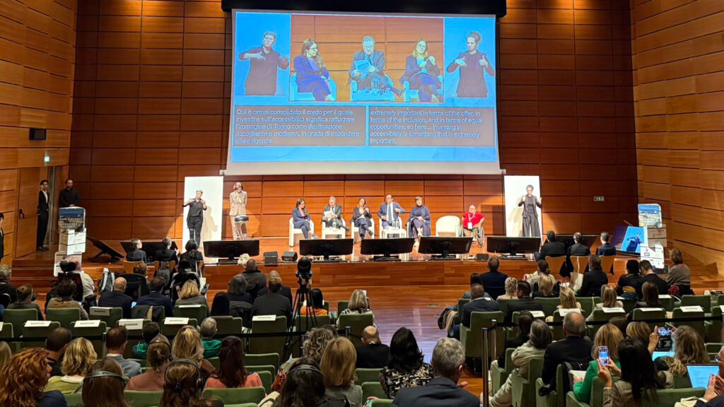 Panel discussion at WSAT 2025 in Turin, Italy, featuring global tourism leaders on stage with sign language interpreters and accessibility subtitles.