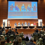 Panel discussion at WSAT 2025 in Turin, Italy, featuring global tourism leaders on stage with sign language interpreters and accessibility subtitles.