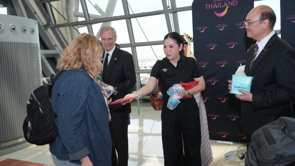 TAT representatives greet travelers from the United Airlines inaugural Los Angeles–Bangkok flight with traditional Thai gifts.
