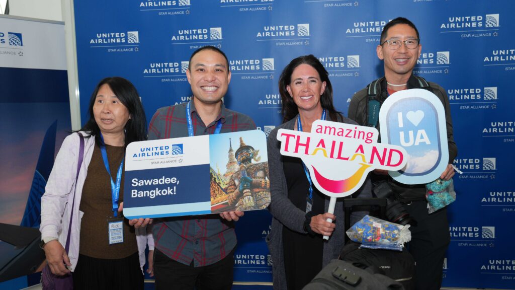 Passengers from United Airlines’ first Los Angeles–Bangkok flight pose with Amazing Thailand and United Airlines signs at Suvarnabhumi Airport.