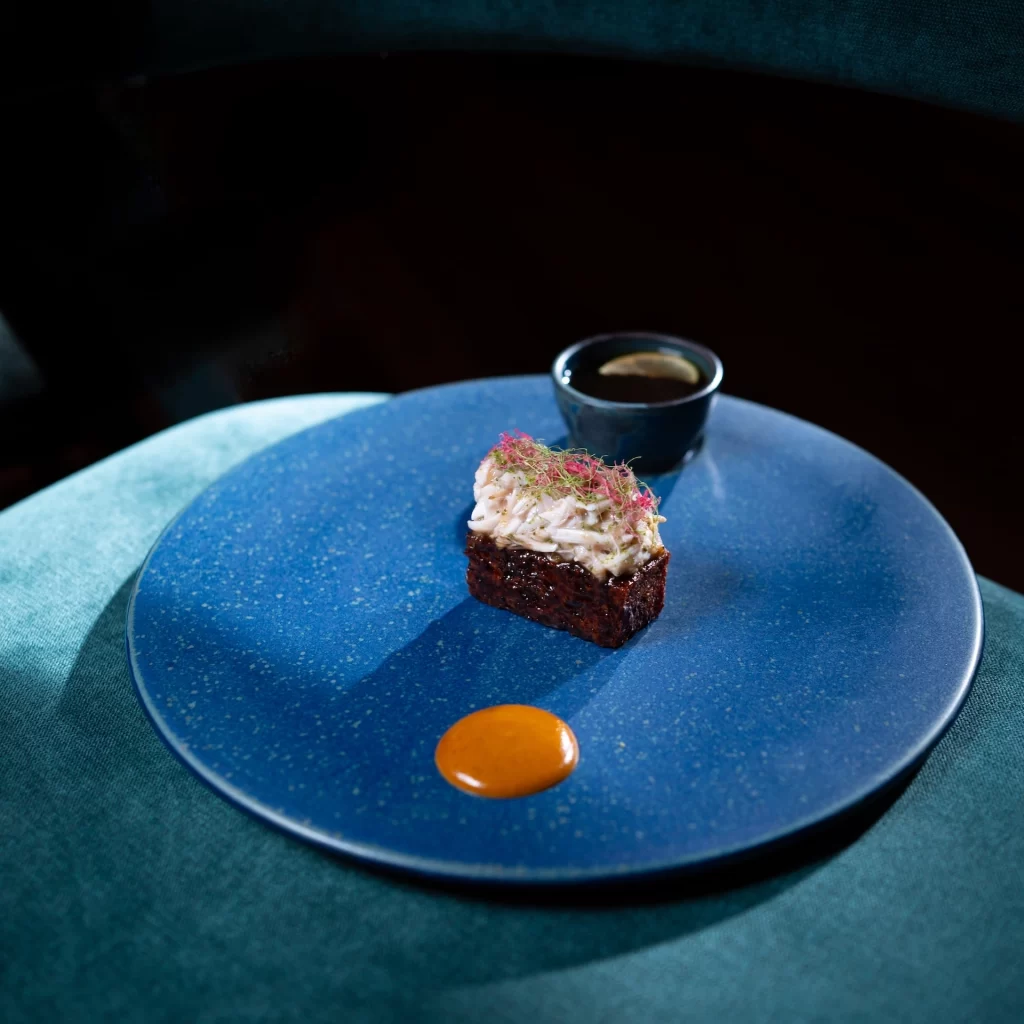 Chef plating a gourmet beef dish under soft lighting at Baan Tepa, highlighting precision, artistry, and sustainable Thai fine dining.