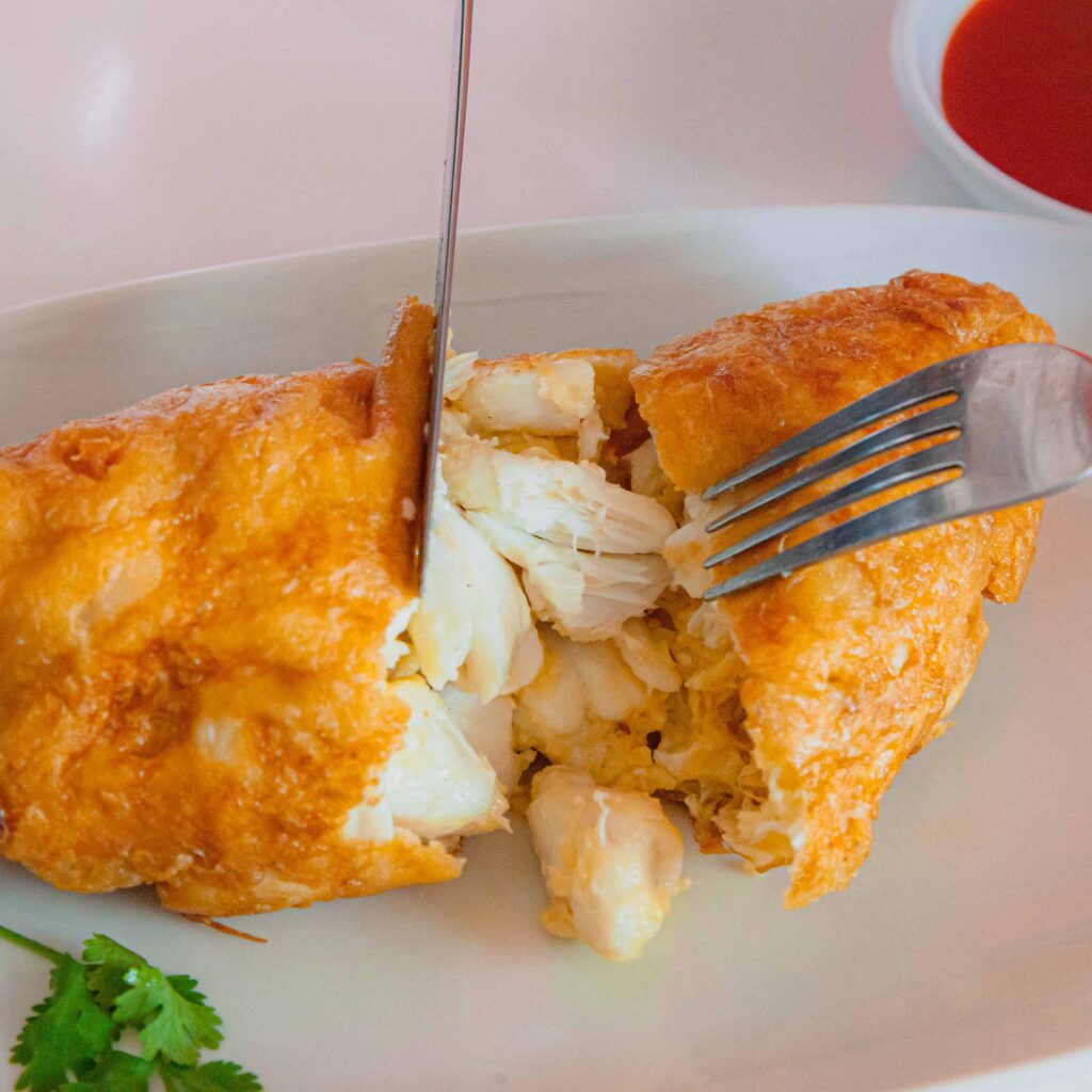 Close-up of Jay Fai’s iconic crab omelette, a golden crispy dish filled with fresh crab meat, representing Thailand’s Michelin-starred street food.