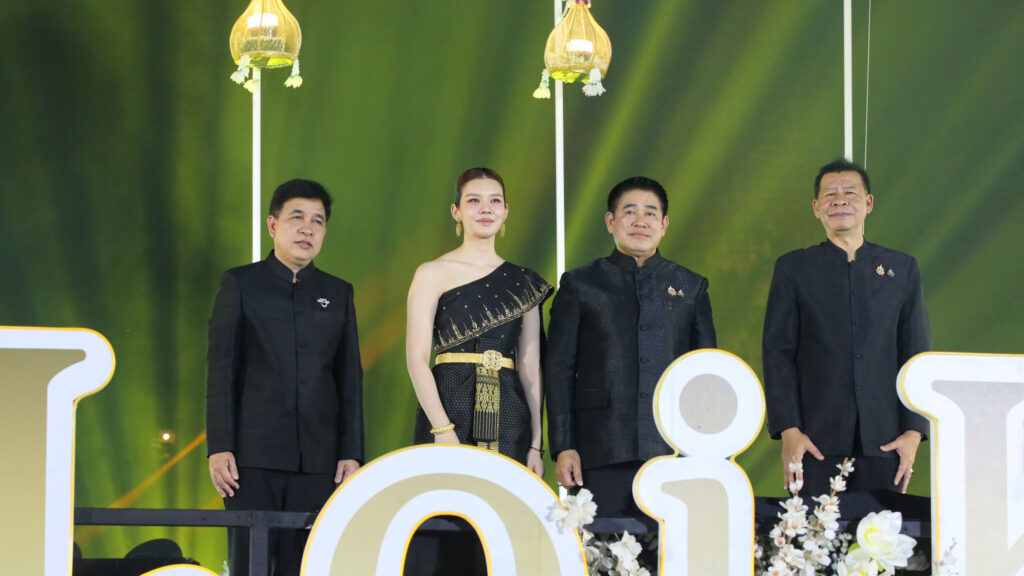 Officials and guests stand on stage during the Maha Loi Krathong @Ayutthaya 2025 opening ceremony at Wat Phra Ram under golden lights.