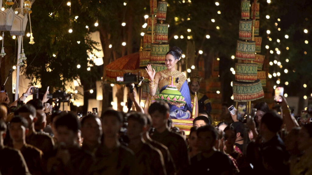 A participant in traditional Thai attire waves to the crowd during the grand Noppamas procession at Maha Loi Krathong @Ayutthaya 2025.