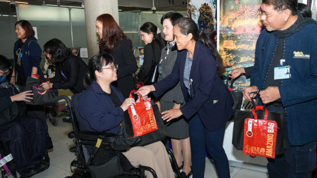 TAT staff greet Taiwanese travellers with mobility impairments, handing out “Amazing Bag” souvenirs as part of the inclusive welcome event.