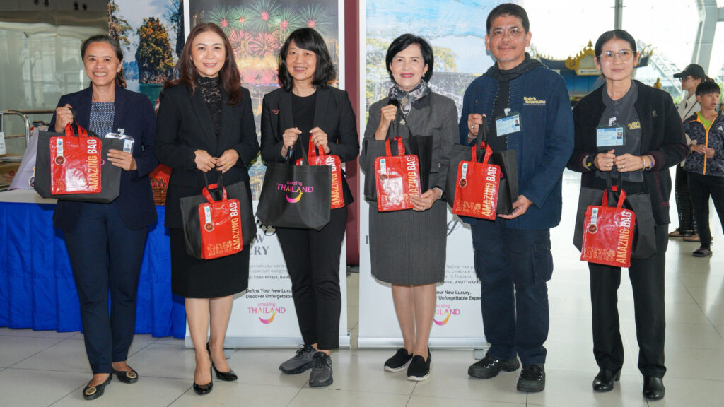 TAT and partner organisation representatives stand together holding “Amazing Bag” souvenirs during the accessible tourism welcome activity.