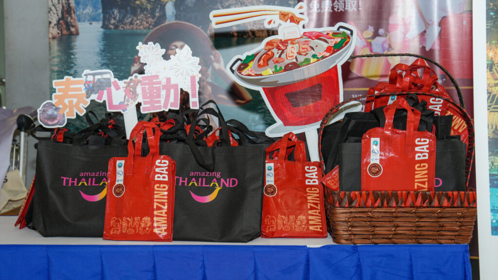 A display of “Amazing Thailand” and red “Amazing Bag” souvenirs arranged on a table for the arriving Taiwanese accessible tourism group.