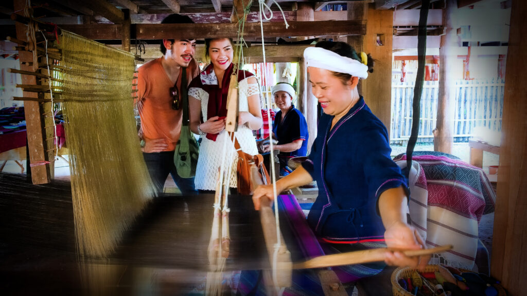 A Tai Lue artisan weaving traditional Lai Nam Lai fabric in Nan Province, showcasing community-based craftsmanship that supports its UNESCO Creative City of Crafts and Folk Art title.