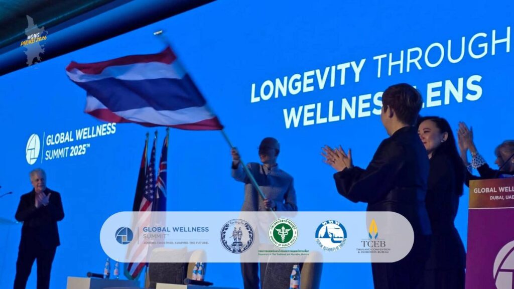 A Thai delegate waves the national flag on stage at the Global Wellness Summit 2025 in Dubai, celebrating Thailand’s selection as host of GWS 2026 in Phuket.