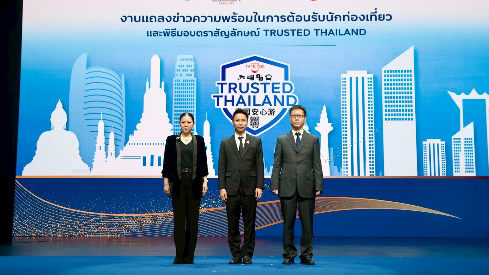 Senior representatives stand on stage at the Trusted Thailand launch event, with the certification logo and city skyline backdrop highlighting Thailand’s tourism safety initiative.