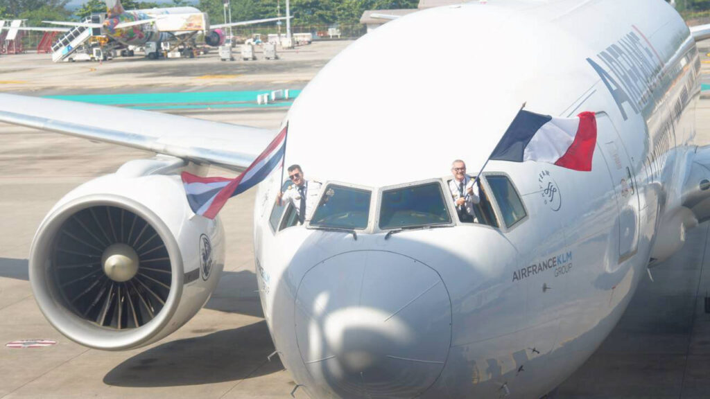 Air France pilots leaning out of the cockpit windows holding the Thai and French flags as the inaugural Paris–Phuket flight arrives in Phuket.