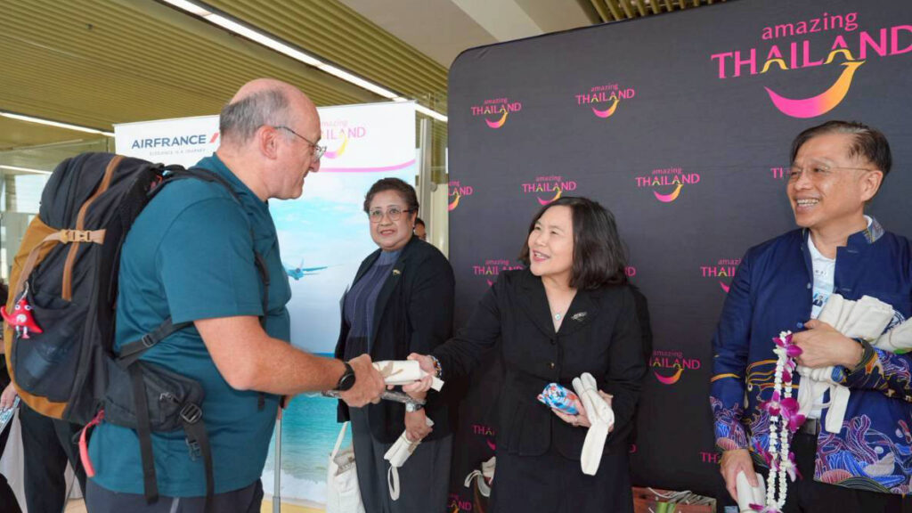TAT representatives welcoming an arriving passenger from the Air France Paris–Phuket inaugural flight with gifts and greetings.