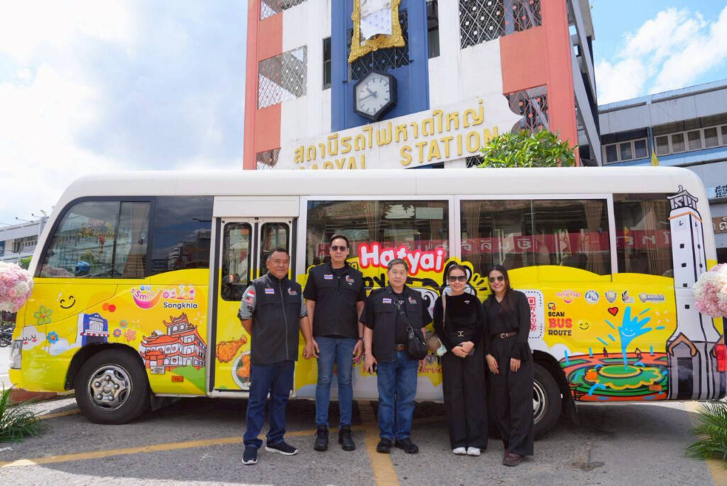 Officials and partners stand beside the Amazing Hatyai Happy Bus at Hat Yai Railway Station, marking the launch of the free city transport service.