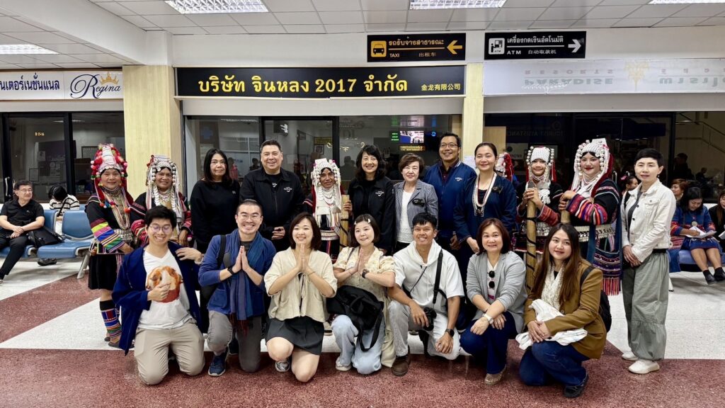 Traditional Lanna performers and tourism partners greet passengers from the inaugural Singapore–Chiang Rai flight at the airport arrival hall.