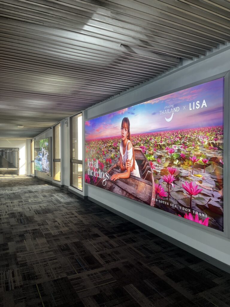 Amazing Thailand x LISA “feel all the feelings” campaign lightbox at Don Mueang International Airport baggage claim featuring Phu Langka Forest Park, Phayao.