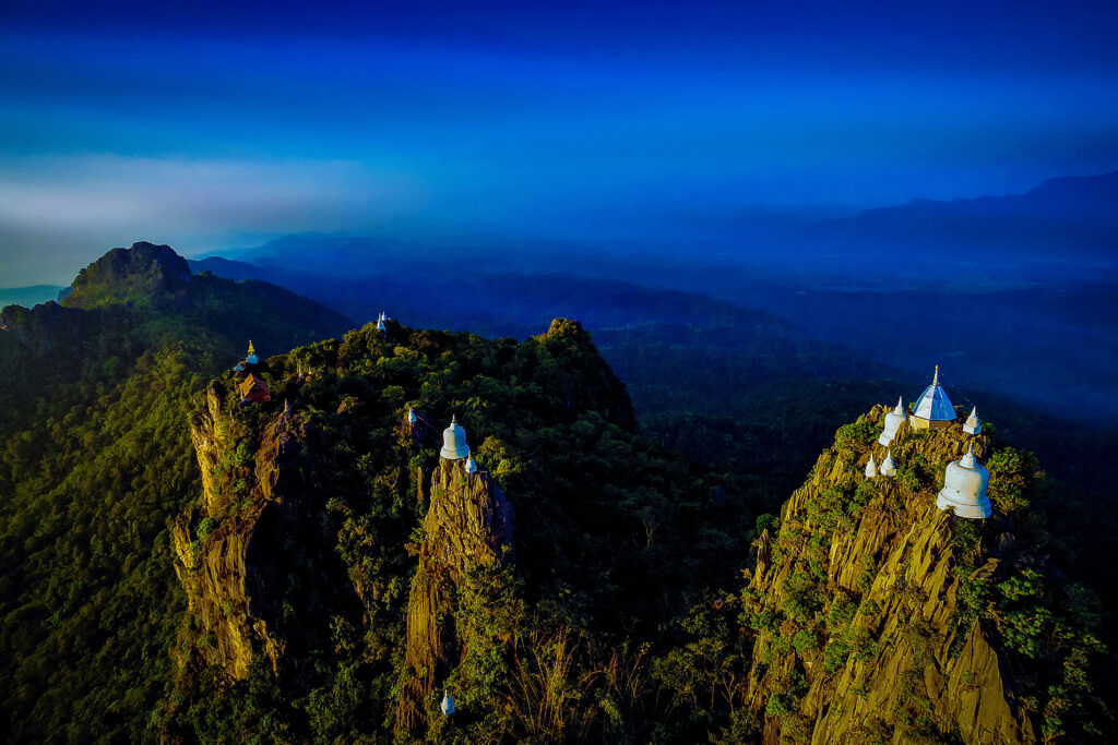 Floating pagodas of Wat Phra Phuthabat Sutthawat atop limestone peaks in Lampang, blending sacred architecture with dramatic mountain scenery.