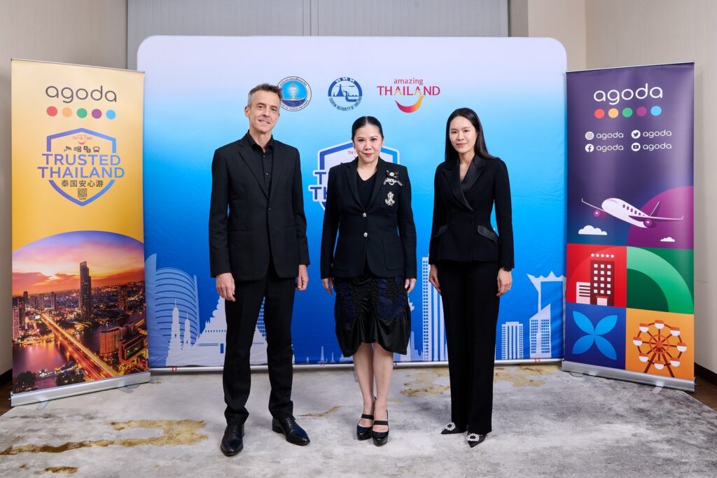 Tourism Authority of Thailand and Agoda executives stand side by side against a Trusted Thailand backdrop, marking continued cooperation to strengthen traveller confidence.