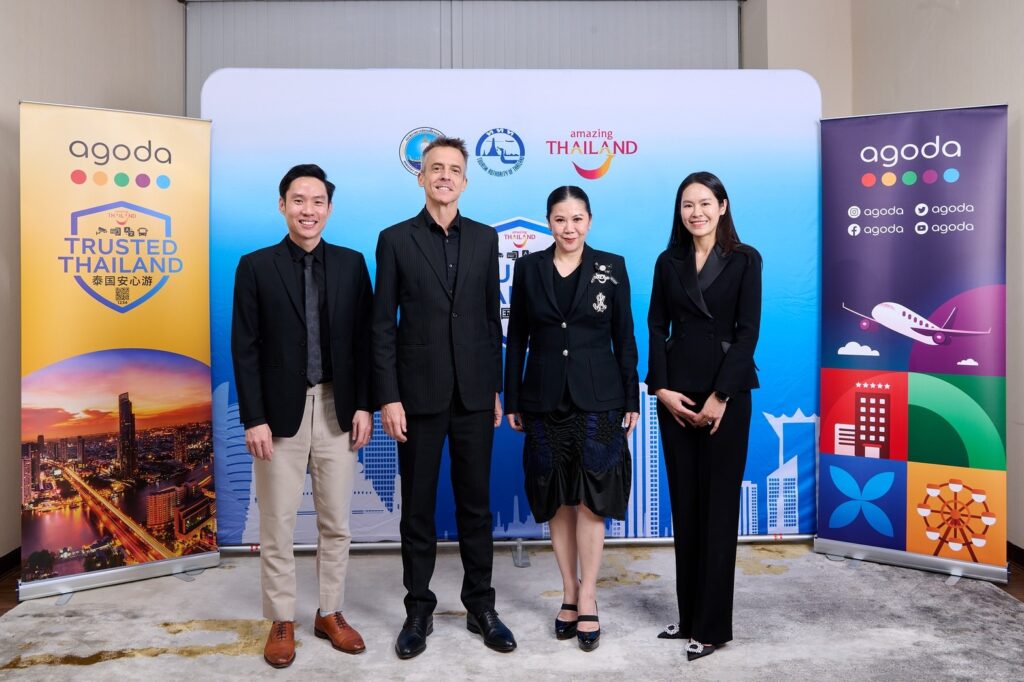Extended group photo of Tourism Authority of Thailand and Agoda executives in formal attire, photographed in front of Trusted Thailand and Agoda promotional backdrops during the partnership engagement.