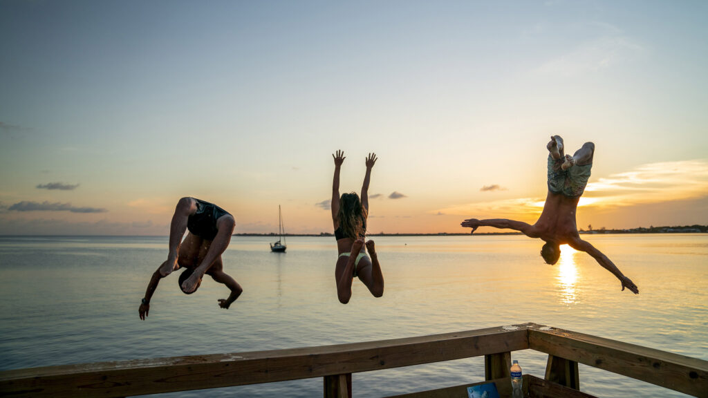 Travellers jump into the sea at sunset reflecting freedom, joy and wellness-led travel experiences in Thailand