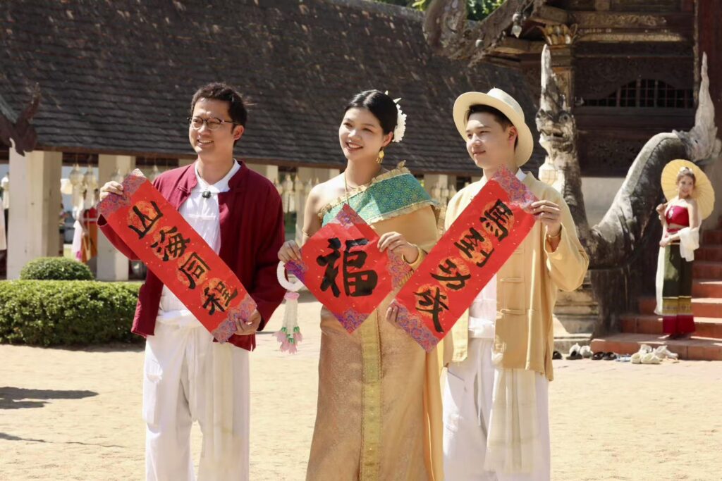 Chinese programme hosts in traditional Thai attire showcasing cultural exchange in Chiang Mai under TAT’s experiential tourism campaign.