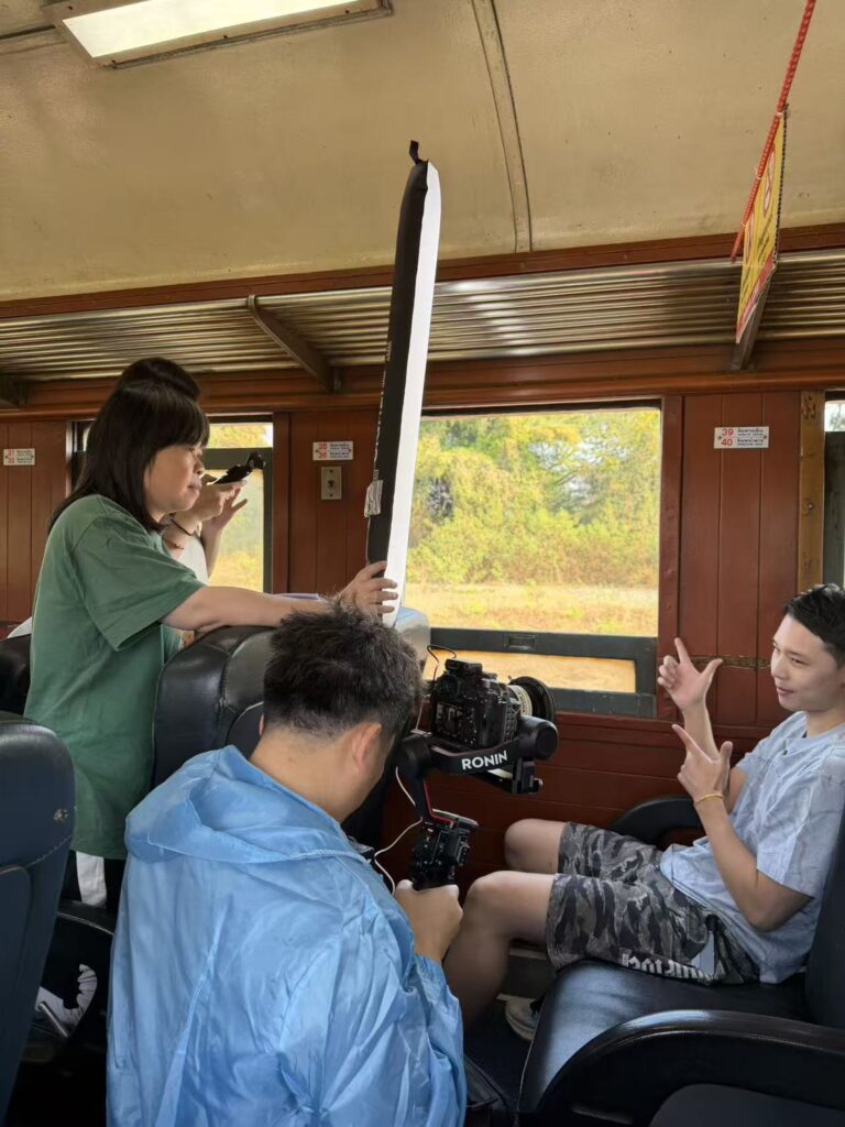 Behind-the-scenes filming inside northern Thailand train carriage for experiential travel storytelling.