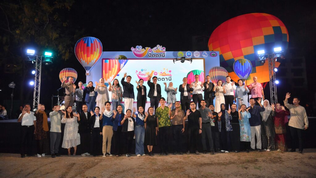 Officials and local community gather at Smile @Pattani festival with illuminated hot air balloons and stage lighting at night