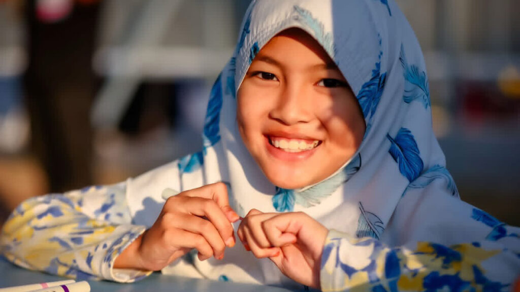 Smiling young girl in traditional attire enjoying Smile @Pattani festival, reflecting local culture and community spirit