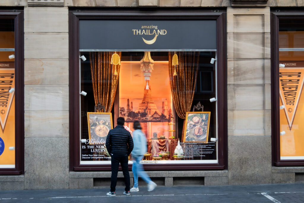Amazing Thailand window display at de Bijenkorf Amsterdam presents Thai cuisine, Wat Arun, and travel inspiration for European visitors.