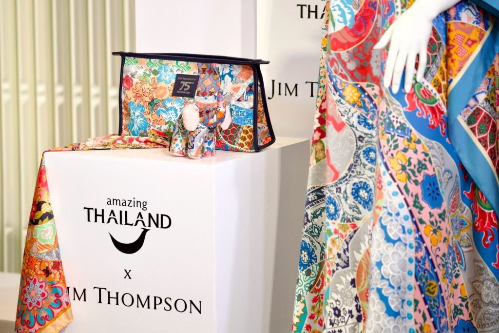 Jim Thompson silk travel clutch and elephant doll displayed with Amazing Thailand branding