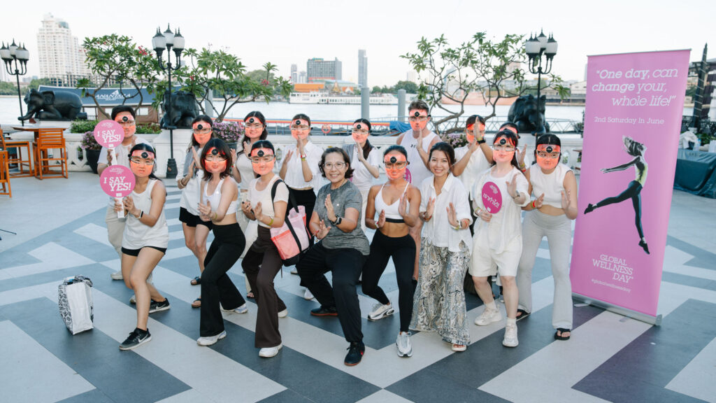 Global Wellness Day 2026 participants pose by the Chao Phraya River after a Thai wellness session in Bangkok.