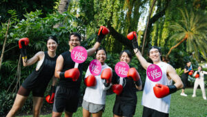 Participants celebrate Global Wellness Day 2026 with Muay Thai-inspired wellness activities in a tropical Thailand setting.