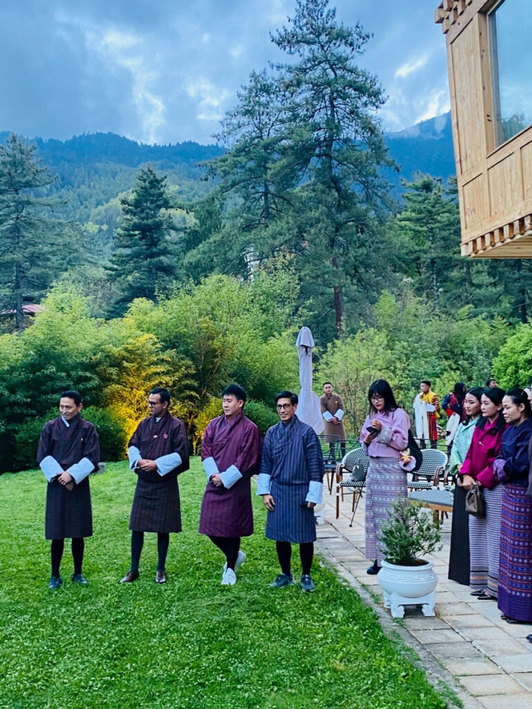 Thai and Bhutanese delegates gather outdoors in Bhutan in traditional attire.