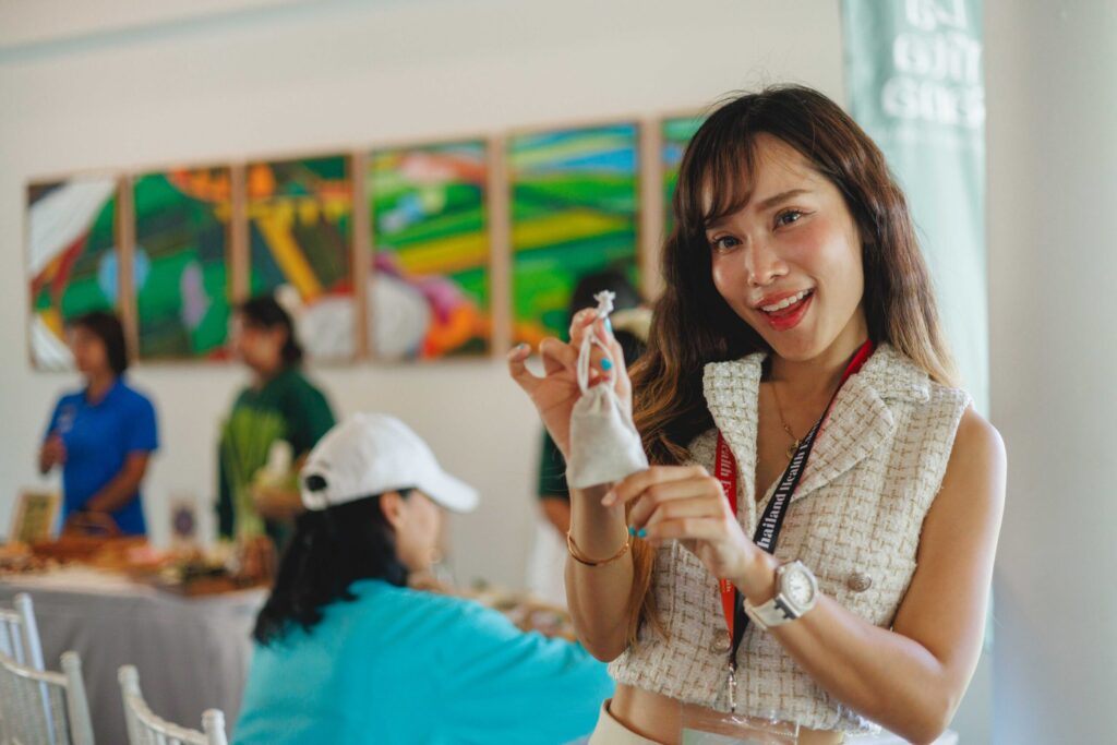 Participant displays a Thai herbal wellness sachet during Thailand Surf Therapy 2026 activities.