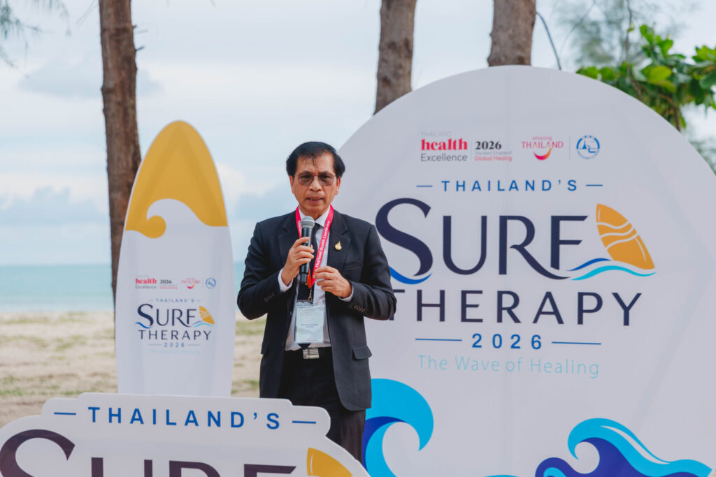 Speaker introduces Thailand Surf Therapy 2026 during a beachside wellness event in Phang-nga.
