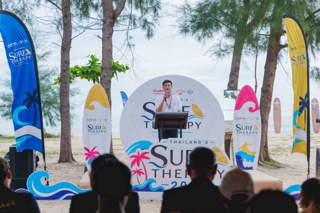 Thailand Surf Therapy 2026 speaker addresses participants at a beachside wellness session in Phang-nga.