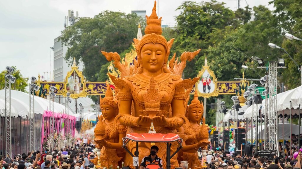 Elaborate wax sculpture leads the Ubon Ratchathani Candle Procession through crowds at Thung Si Mueang.