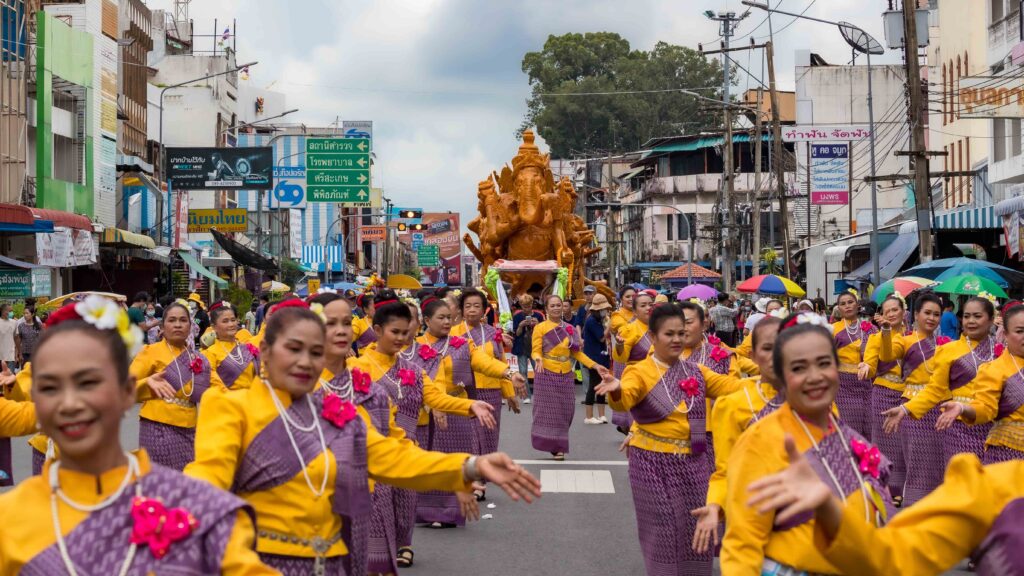Traditional dancers perform ahead of an ornate candle float during the Ubon Ratchathani Candle Procession.