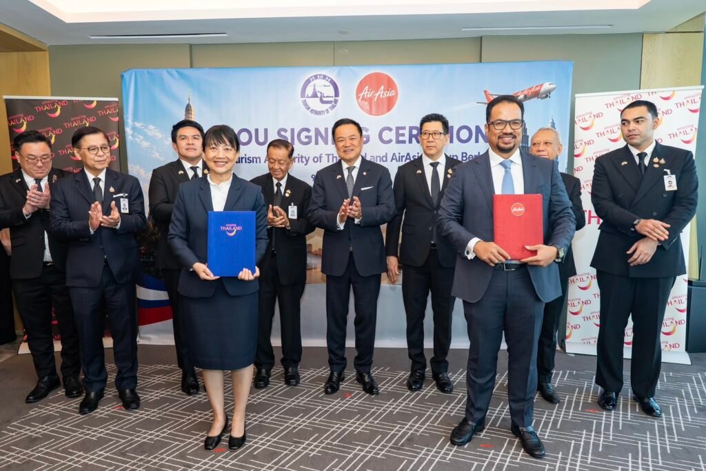 TAT and AirAsia Group representatives hold signed MOU folders as Thai government officials witness the tourism partnership ceremony in Kuala Lumpur.