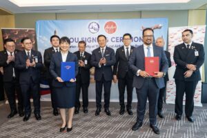 TAT and AirAsia Group representatives hold signed MOU folders as Thai government officials witness the tourism partnership ceremony in Kuala Lumpur.