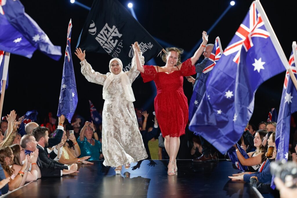 Delegates walk on stage surrounded by Australian flags during the Bangkok gathering.
