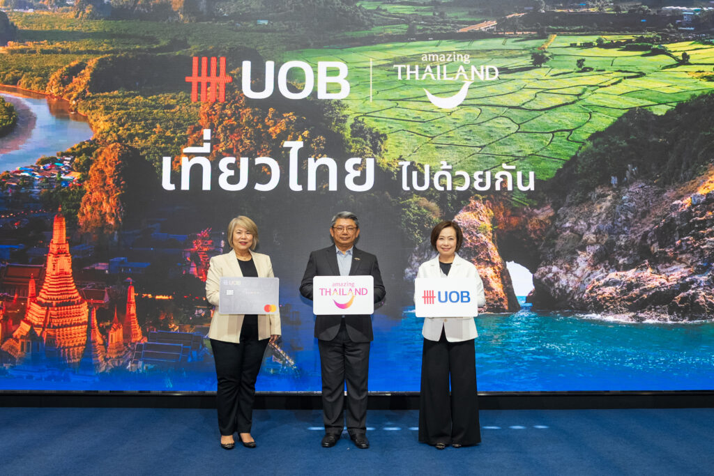 TAT and UOB representatives pose before a colourful Travel Thailand Together campaign backdrop featuring Thai destinations.