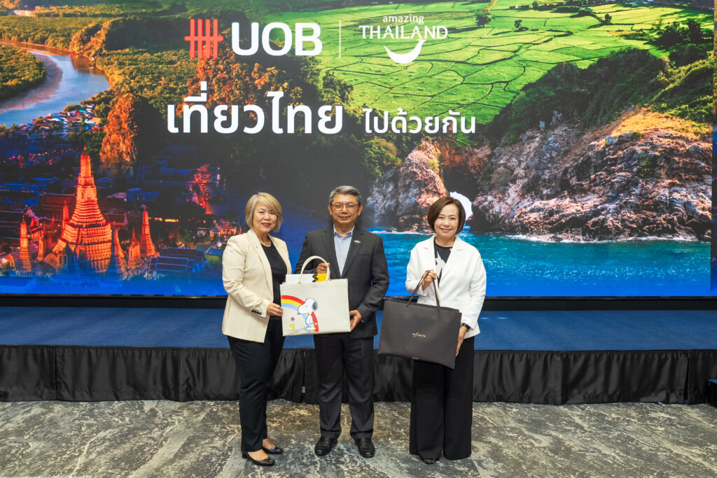 TAT and UOB representatives present campaign gifts, including a Snoopy premium, at the Travel Thailand Together launch.